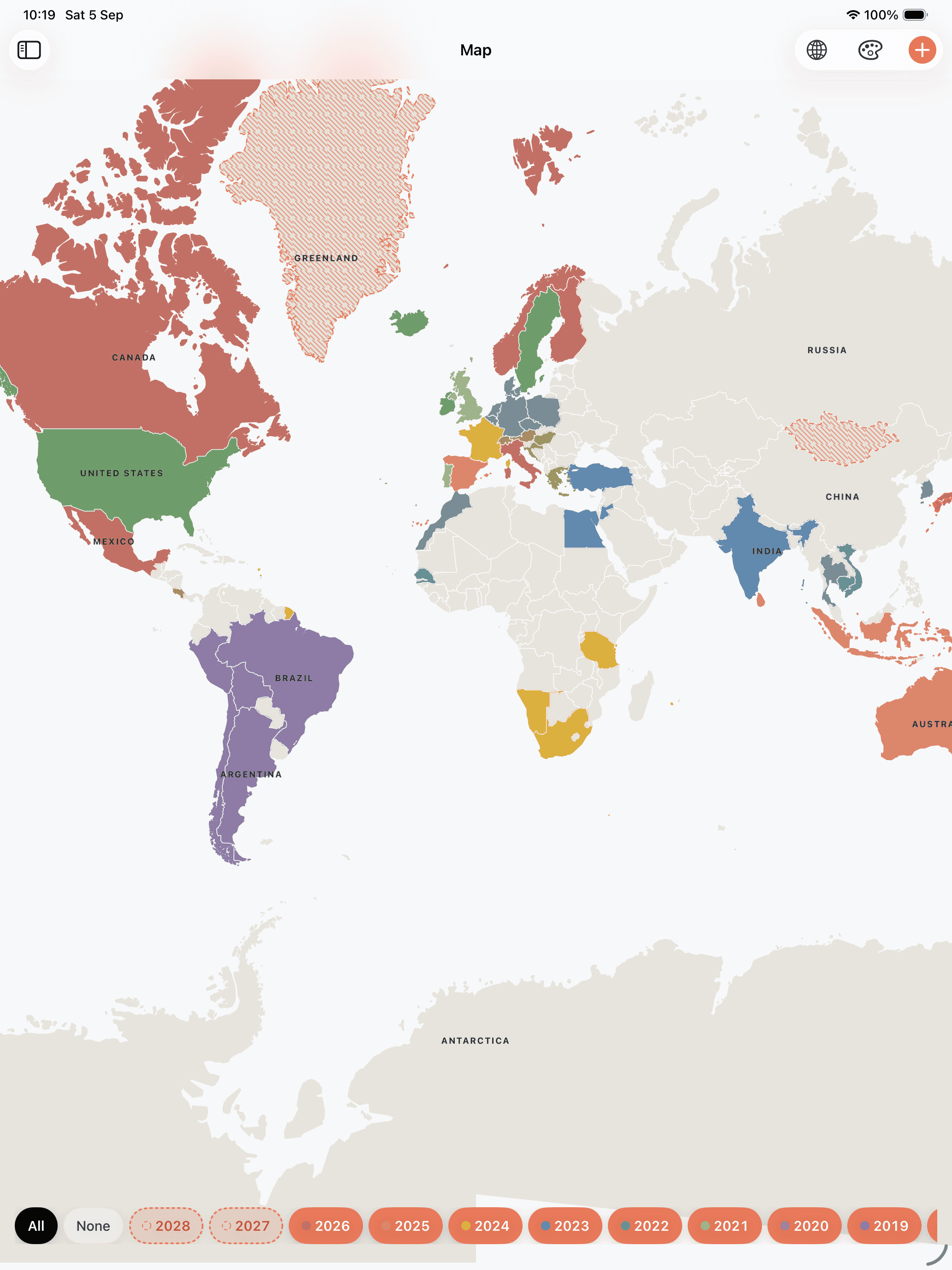 The same world, each country now in the colour of a year: Canada in brick red, the United States in green, Brazil and Argentina in violet, Greece and India in blue, Namibia and South Africa in ochre.